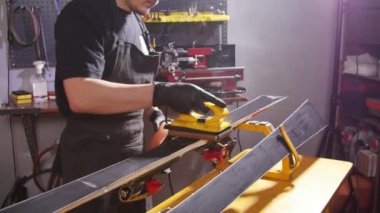 Kayak veya snowboard atoksve reapair kavramı. Temel onarım ve servis yapan kış dükkanı işçisi