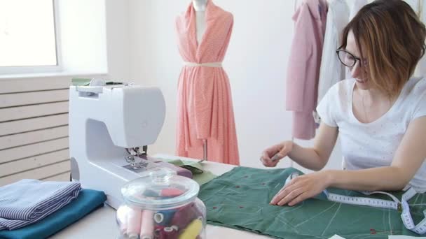 Concepto de hobby y pequeña empresa. Joven diseñadora femenina diseña ropa en un brillante taller de estudio — Vídeos de Stock