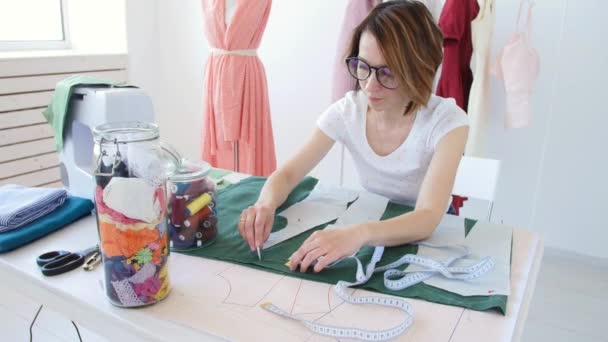 Concepto de hobby y pequeña empresa. Joven diseñadora femenina diseña ropa en un brillante taller de estudio — Vídeos de Stock