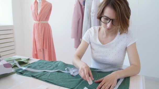 Concepto de hobby y pequeña empresa. Joven diseñadora femenina diseña ropa en un brillante taller de estudio — Vídeo de stock