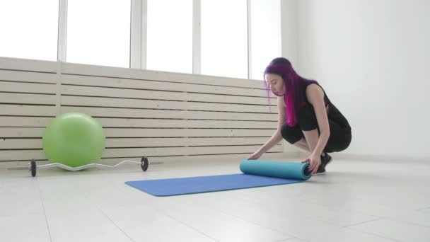 Spor, sağlık ve rahatlama kavramı. Bir daire veya spor salonunda bir yoga minderi ve egzersizleri ile genç kadın — Stok video