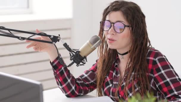 Podcasting och radio koncept. Radio värd ung kvinna i studion framför en mikrofon — Stockvideo