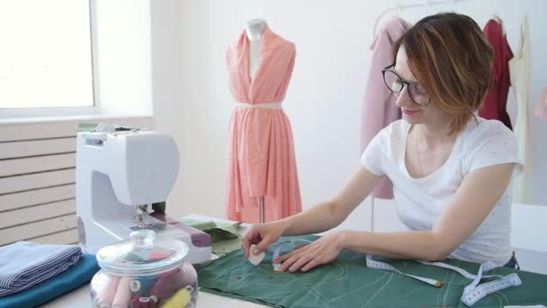 Hobby en kleine bedrijven. Jonge vrouwelijke kleermaker werken met doek stof in workshop — Stockvideo