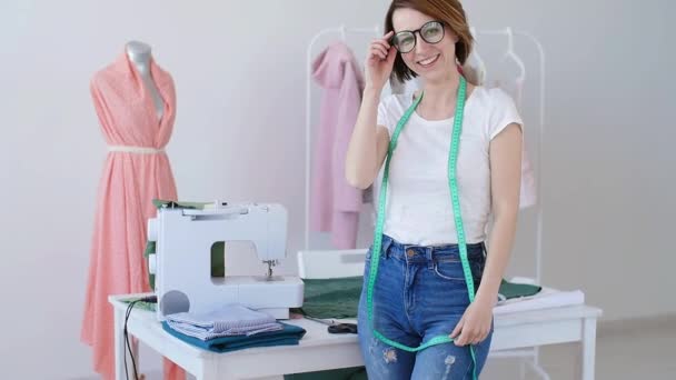 Konzept von Hobby und Kleinunternehmen. schöne junge Schneiderin lächelt in die Kamera — Stockvideo