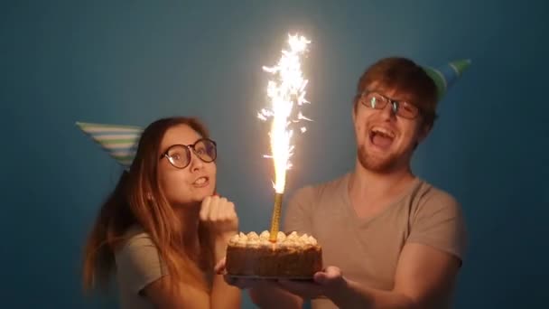 Concepto de vacaciones y cumpleaños. Joven alegre divertida pareja divirtiéndose con pastel de cumpleaños — Vídeos de Stock