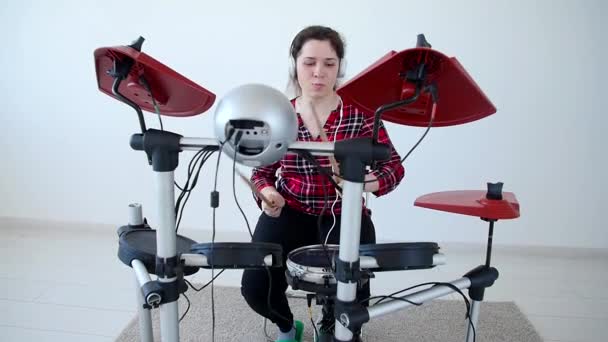 Concept van hobby en muziek. Jonge vrouw drummer oefenen elektronische drum kit thuis — Stockvideo