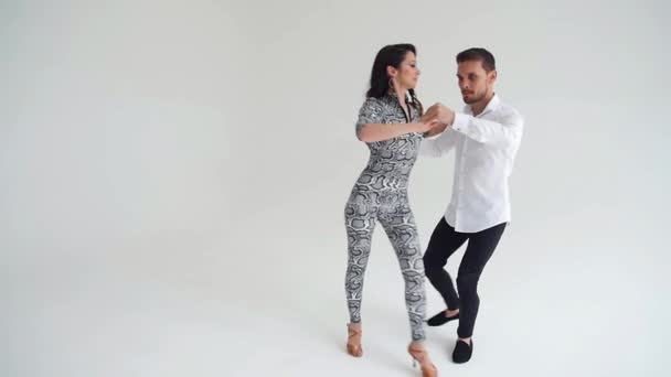 Konzept von Liebe, Beziehungen und sozialem Tanzen. junges schönes Paar tanzt sinnlichen Tanz auf weißem Hintergrund — Stockvideo