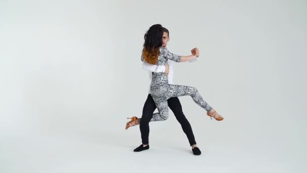 Begreppet kärlek, relationer och social dans. Unga vackra par dansar sensuell Dans på en vit bakgrund — Stockvideo