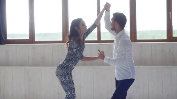 Concept d'amour, de relations et de danse sociale. Jeune beau couple dansant danse sensuelle sur fond blanc — Video