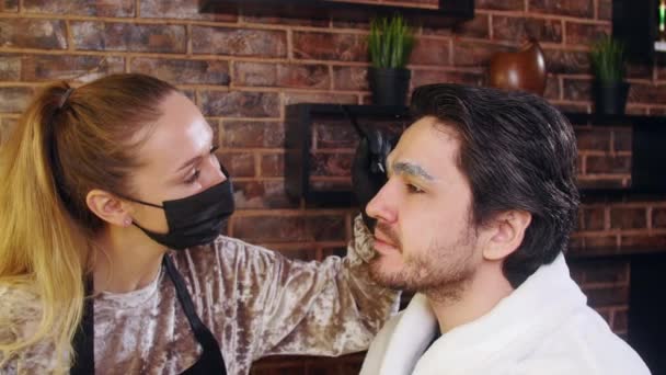 Young stylish man in a beauty salon. Face and eyebrow care — ストック動画