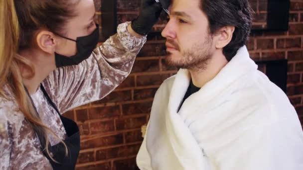 Joven hombre con estilo en un salón de belleza. Cuidado de la cara y las cejas — Vídeos de Stock