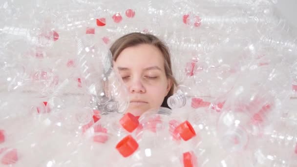 La femme malade déshydratée est allongée dans une pile de bouteilles en plastique. Problème de pollution environnementale. Arrêter la nature déchets environnement protection concept — Video