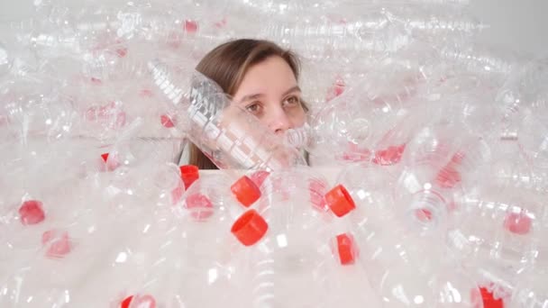 Eine dehydrierte, kranke Frau liegt in einem Stapel Plastikflaschen. Umweltverschmutzung. Naturmüll Umweltschutzkonzept stoppen — Stockvideo