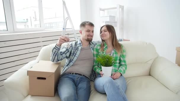 Concept d'achat et de location immobilier. Joyeux jeune couple montrant les clés de la nouvelle maison — Video