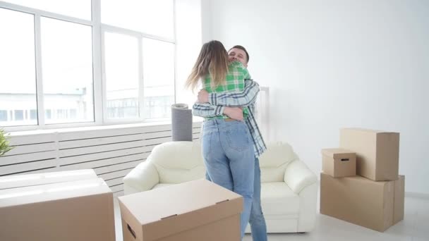 Concepto de compra y alquiler de bienes raíces. Suerte pareja abrazando en nueva casa — Vídeos de Stock
