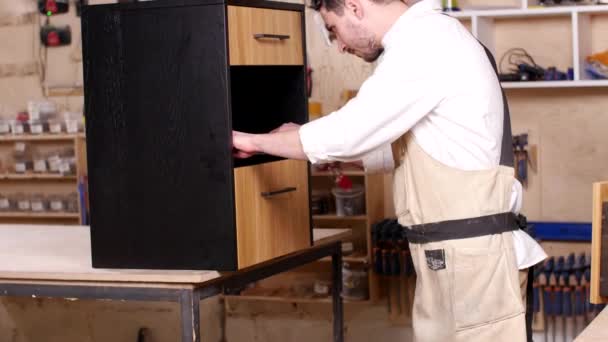 Concepto de negocio y fabricación. Joven en el taller monta muebles — Vídeo de stock