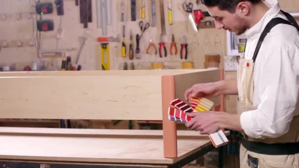 Concepto de negocio y fabricación. Joven en el taller monta muebles — Vídeos de Stock