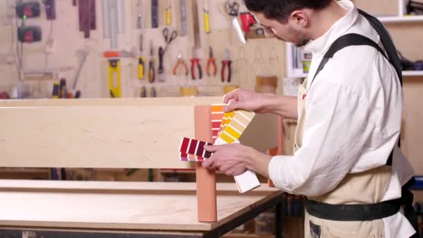 Concept of business and manufacture. Young man in the workshop assembles furniture — Stock Footage Concept of business and manufacture. Young man in the workshop assembles furniture Video Clip