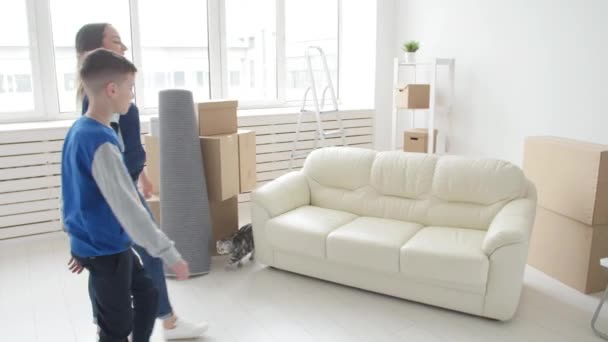 Junge Mutter und Sohn ziehen in eine neue Wohnung — Stockvideo