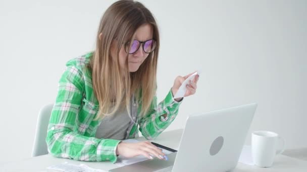 Frau berücksichtigt die Höhe der Ausgaben für Einkäufe und die Zahlung von Gutschriften, indem sie Informationen in Laptop für die Buchhaltung zu Hause eingibt. Konzept von Sparen und Geld — Stockvideo