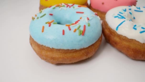 Pürüzsüz bir hareketle lezzetli çok renkli sırlı donutlar. — Stok video