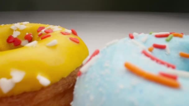 Pürüzsüz bir hareketle lezzetli çok renkli sırlı donutlar. — Stok video