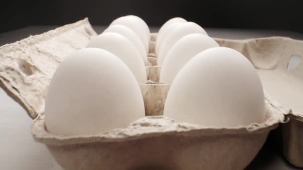 Rohe frische Eier in Packung auf weißem Tisch, Slide-Shooting — Stockvideo