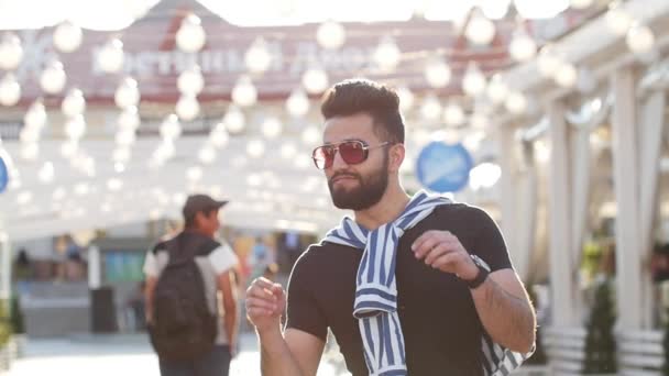 Joven elegante sonriente árabe o latino joven en una calle de la ciudad — Vídeos de Stock