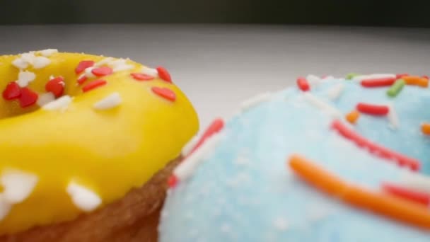 Beyaz bir arka plan üzerinde lezzetli çok renkli donutlar. Pürüzsüz dolly hareketi — Stok video