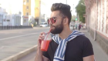 Sokak yemekleri ve şehir hayatı kavramı. Genç gülümseyen sakallı adam içecek suyu smoothies veya limonata ile bir fincan tutan