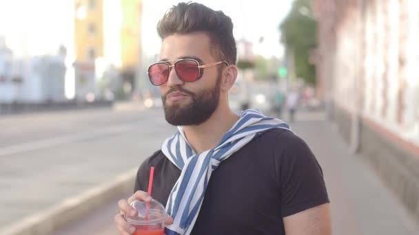 Concepto de comida callejera y vida urbana. Joven hombre barbudo sonriente sosteniendo una taza con batidos de jugo de bebida o limonada — Vídeos de Stock