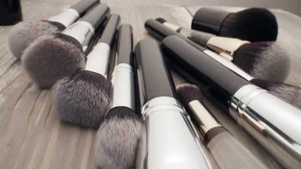 Cosmetics and beauty concept. Make-up brushes on wooden table — Stock Video