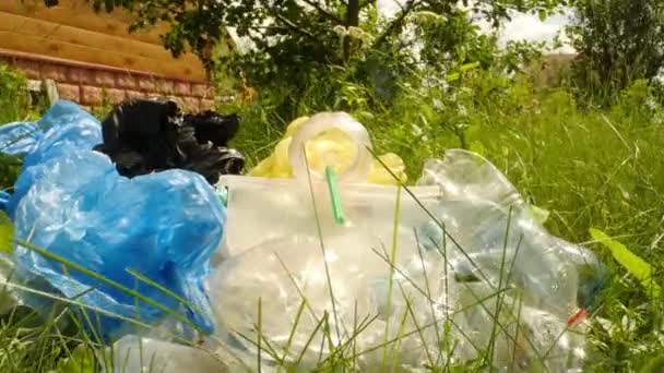 Concepto de contaminación del planeta y desastre ambiental. Una mirada dentro de la botella de plástico usado en hierba verde — Vídeos de Stock