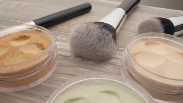 Concept of beauty and skin care. Cosmetic powder and brushes on the wooden table, dolly shoot — Stock Video
