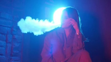 Genç kadın renkli bir ışık üzerinde Club buharlaştırıcı sigara