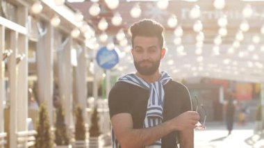Mutlu genç bir şehir sokakta güneş gözlüğü şık adam gülümseyen