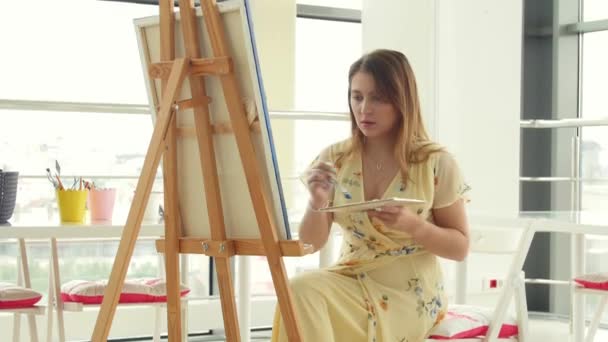 Art, creativity, hobby, job and creative occupation concept. Young cute girl draws in art workshop — Stock Video