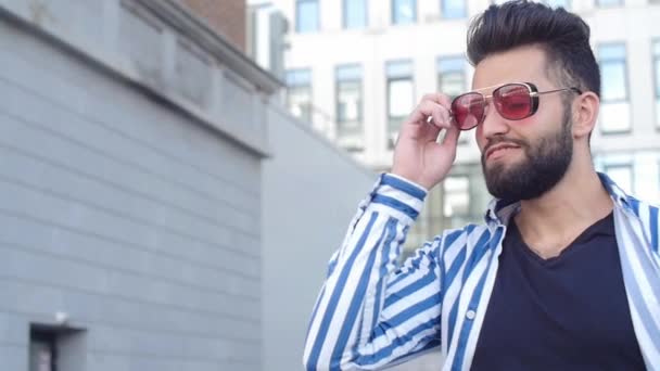 Šťastný mladý usměvavý stylový chlapík v slunečních brýlích na městské ulici — Stock video