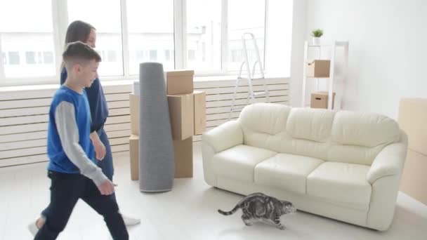 Jovem mãe e filho estão se mudando para um novo apartamento — Vídeo de Stock