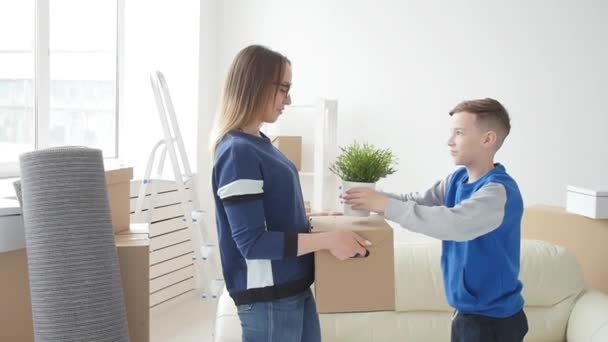 Jovem mãe e filho estão se mudando para um novo apartamento — Vídeo de Stock