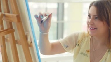 Sanat, yaratıcılık, hobi, iş ve yaratıcı meslek kavramı. Stüdyoda Resim Üzerine Çalışan Kadın Sanatçı