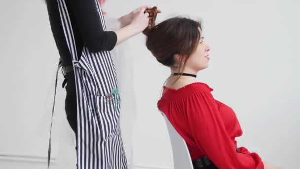 Jeune femme aux cheveux roux coupe les cheveux à la femme chez le coiffeur — Video