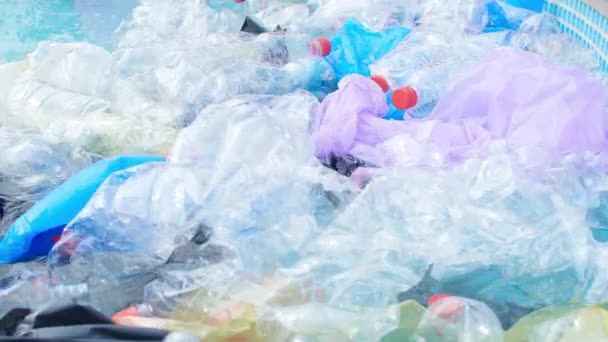 Концепція забруднення планети. Пластикові пакети та пляшки плавають на воді — стокове відео
