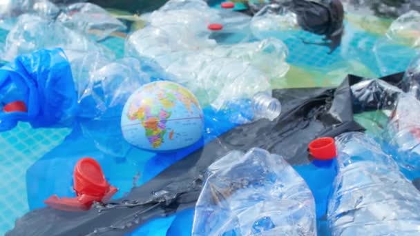 Concept van vervuiling van de planeet en niet-recycleerbaar afval. Een wereldbol zwevend onder plastic Prullenbak — Stockvideo