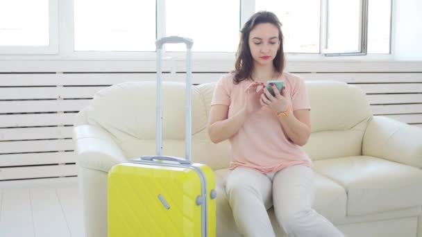 Utazás, utazás, és a vakáció koncepció-nő sárga bőrönde várja a taxi — Stock videók