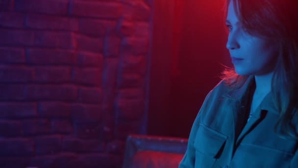 Mladá žena v neonově červeném a modrém dýmu s vopice nebo e-cigaretami — Stock video