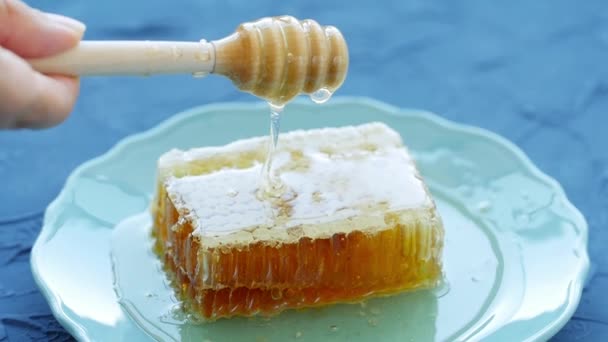 天然生态食品概念。手握蜂蜜主轴。盘子里的甜蜂巢 — 图库视频影像