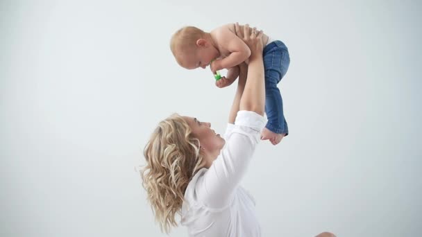 Rodičovský, mateřský a dětský koncept-matka, která drží sladkou holčičku na bílém pozadí — Stock video