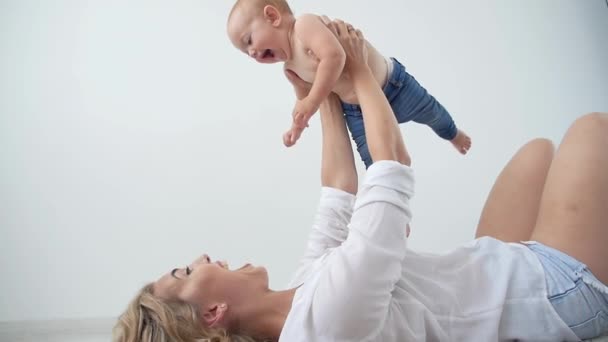 Samotna rodzic, macierzyństwo i koncepcja niemowlęctwo-matka trzymanie słodkiej dziewczynki na białym tle — Wideo stockowe