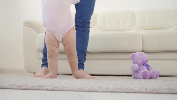 El bebé dando los primeros pasos con las madres ayuda en casa — Vídeo de stock